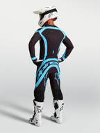 Alpinestars Pantaloni Supertech Vesta, pantaloni motocross professionali da uomo, nero e turchese, vista posteriore su modello, design atletico per alte prestazioni off-road.