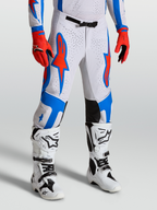 Alpinestars Pantaloni Supertech Vesta, pantaloni da motocross bianchi e rossi con grafiche blu, vestibilità atletica da gara su modello, abbigliamento off-road pro level