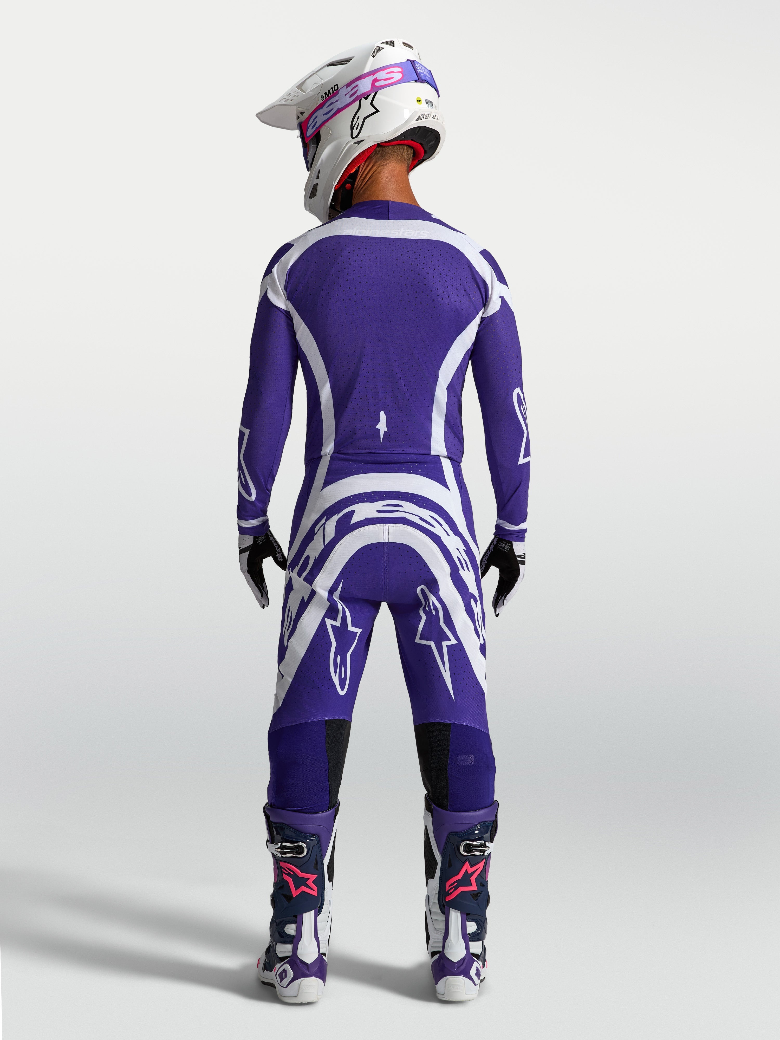 Pantaloni e maglia Alpinestars Supertech Vesta, completo da motocross racing blu e bianco, vista posteriore su modello.