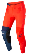 Pantaloni Alpinestars Supertech Blaze, pantaloni da motocross fuoristrada, rosso acceso e blu scuro con accenti bianchi, inserti interni alle ginocchia in pelle nera, chiusura regolabile a cricchetto in vita, loghi Alpinestars bianchi e blu, struttura elasticizzata resistente per motocross.