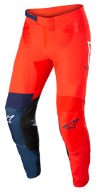Pantaloni Alpinestars Supertech Blaze, pantaloni da motocross fuoristrada, rosso acceso e blu scuro con accenti bianchi, inserti interni alle ginocchia in pelle nera, chiusura regolabile a cricchetto in vita, loghi Alpinestars bianchi e blu, struttura elasticizzata resistente per motocross.
