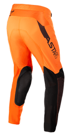 Alpinestars Supertech Blaze Pants, pantaloni da motocross, arancione e nero con giallo fluo, vista posteriore a tre quarti con rinforzi in pelle nera sulle ginocchia, marchio ASTARS sulla coscia e pannelli in mesh traspirante, progettati per la guida su sterrato a livello professionale