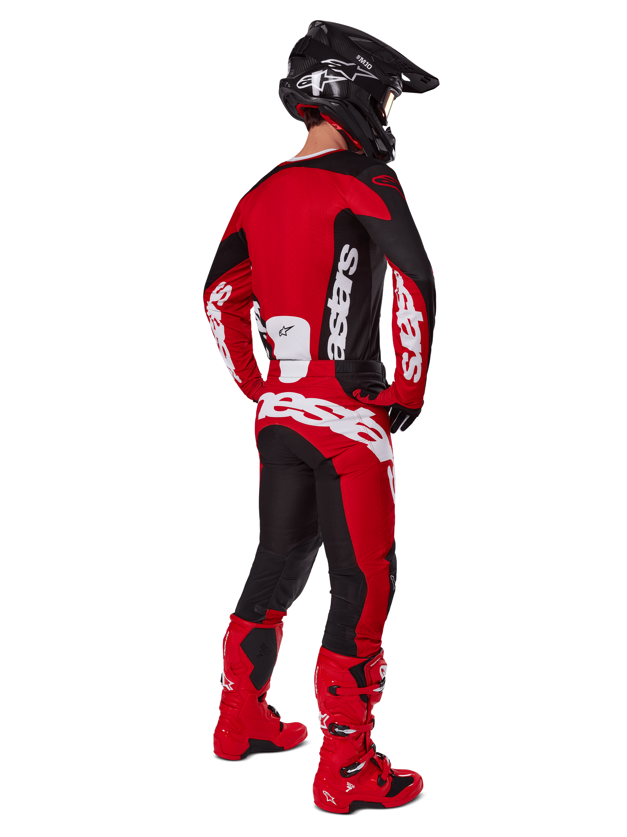 Pantaloni Alpinestars Racer Veil 2025, pantaloni da motocross, nero e rosso vivace, visti dal retro su un pilota che indossa maglia coordinata, stivali rossi e casco nero, con branding Alpinestars bianco e un design off-road orientato alle prestazioni