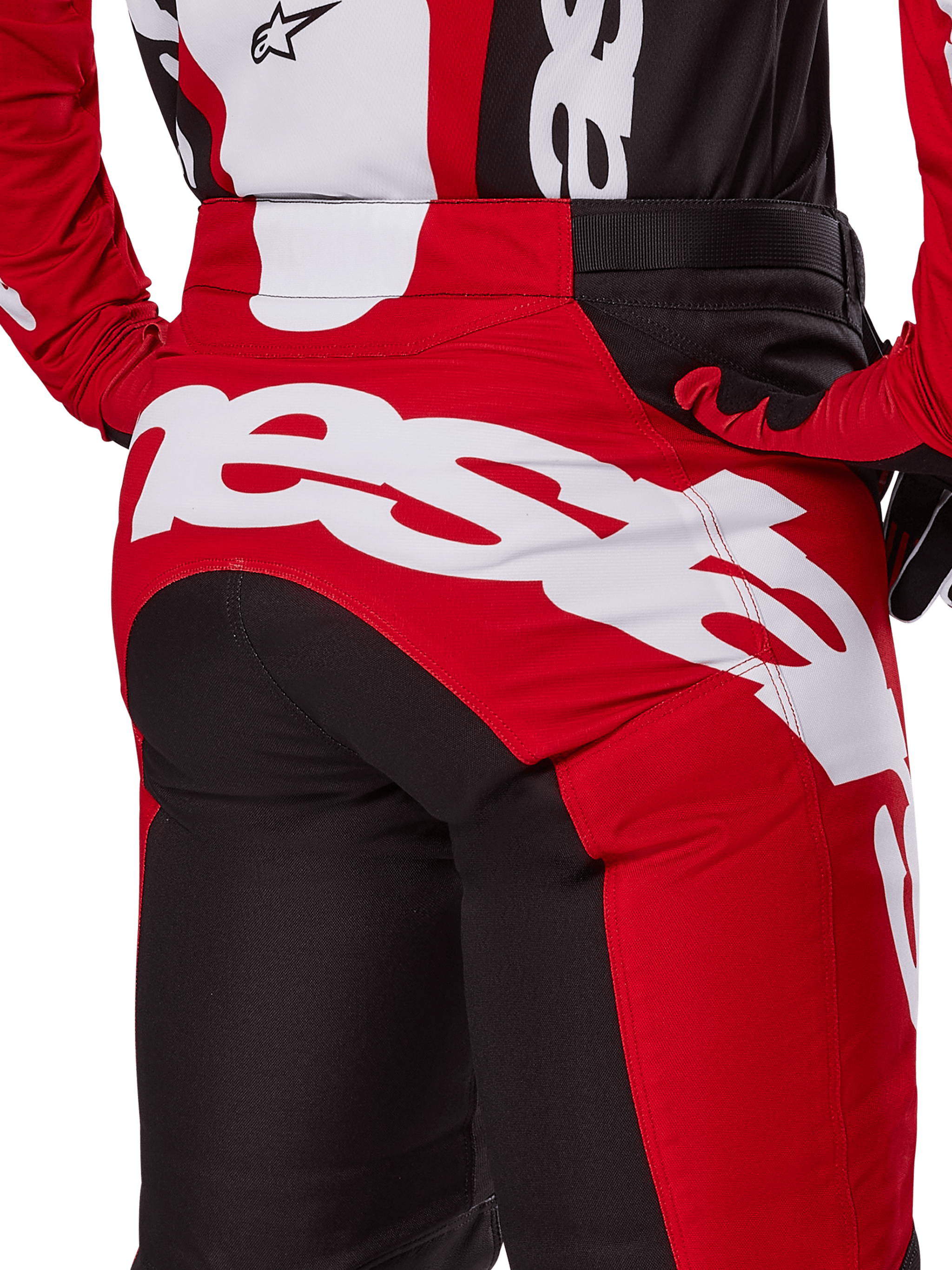 Alpinestars 2025 Pantaloni Racer Veil, pantaloni da motocross, nero e rosso brillante, vista ravvicinata della zona della seduta posteriore con grande logo Alpinestars bianco, pannelli tecnici rossi e neri, indossati con abbigliamento coordinato