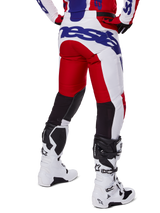 Alpinestars 2025 Racer Veil Pants, pantaloni da motocross, rosso acceso e bianco con logo blu, vista posteriore che mostra i pannelli di ventilazione neri sul retro delle gambe, abbinati a stivali da motocross bianchi