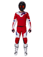 Pantaloni Alpinestars 2025 Racer Veil e set completo di abbigliamento da motocross, rosso acceso e bianco con accenti blu, maglia coordinata, casco nero con occhiali arancioni, stivali bianchi e neri e guanti rossi, look coordinato per gare fuoristrada