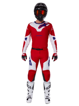 Pantaloni Alpinestars 2025 Racer Veil e set completo di abbigliamento da motocross, rosso acceso e bianco con accenti blu, maglia coordinata, casco nero con occhiali arancioni, stivali bianchi e neri e guanti rossi, look coordinato per gare fuoristrada