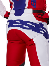 Alpinestars 2025 Racer Veil Pants, pantaloni da motocross, rosso brillante e bianco con branding blu, dettaglio posteriore della zona della seduta con grande logo Alpinestars, indossati come parte di un completo coordinato