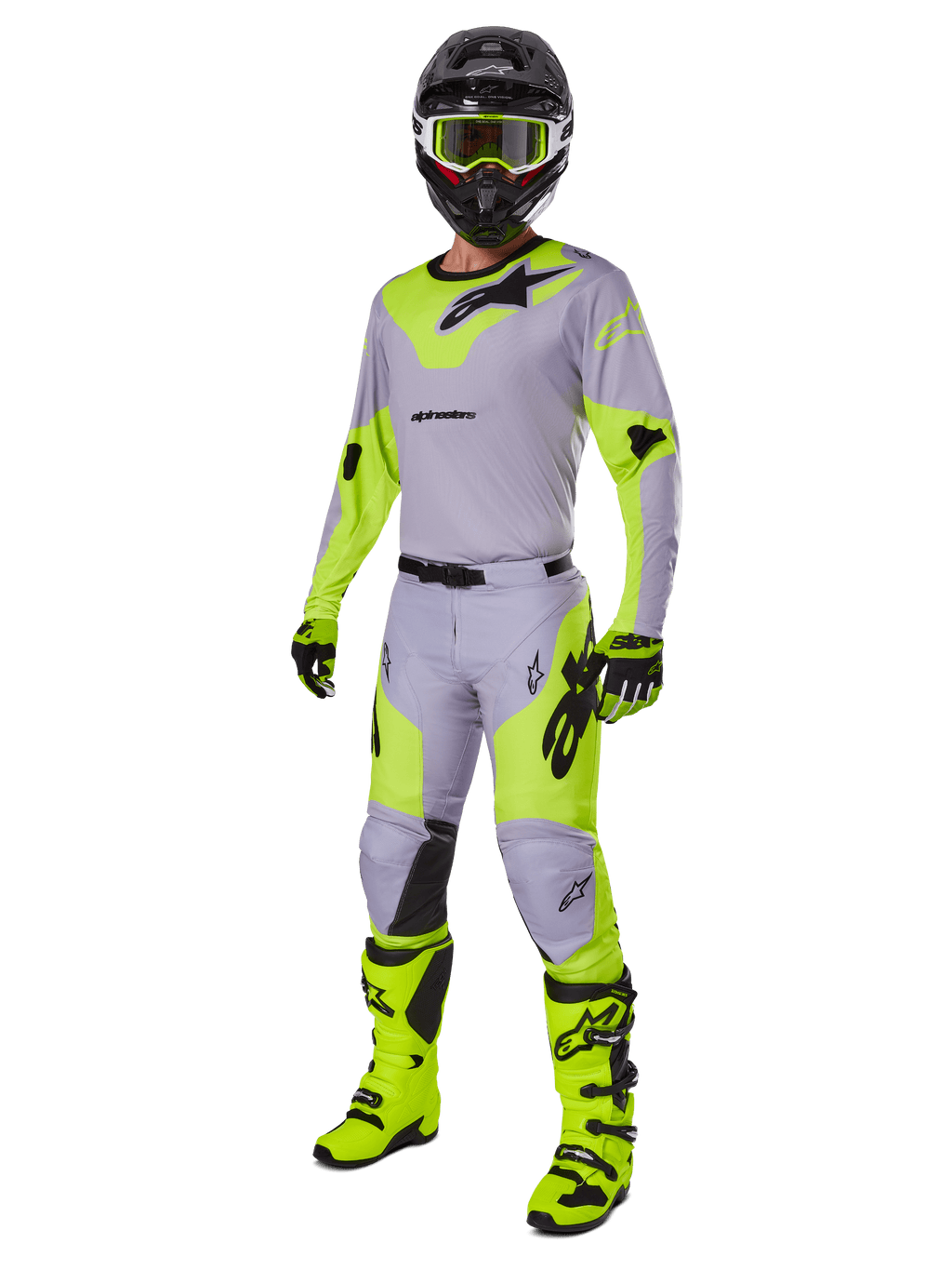Pantaloni Alpinestars Racer Veil 2025, pantaloni da motocross, grigio e giallo fluo, indossati con maglia coordinata, casco nero, maschera giallo fluo, stivali e guanti, completo da gara off-road coordinato con design ergonomico e loghi evidenti.