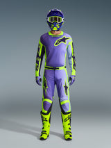 Alpinestars 2026 Racer Portl Pants e set completo da motocross, pilota in viola e giallo fluo con maglia coordinata, casco, occhiali e stivali giallo brillante, abbigliamento per prestazioni fuoristrada