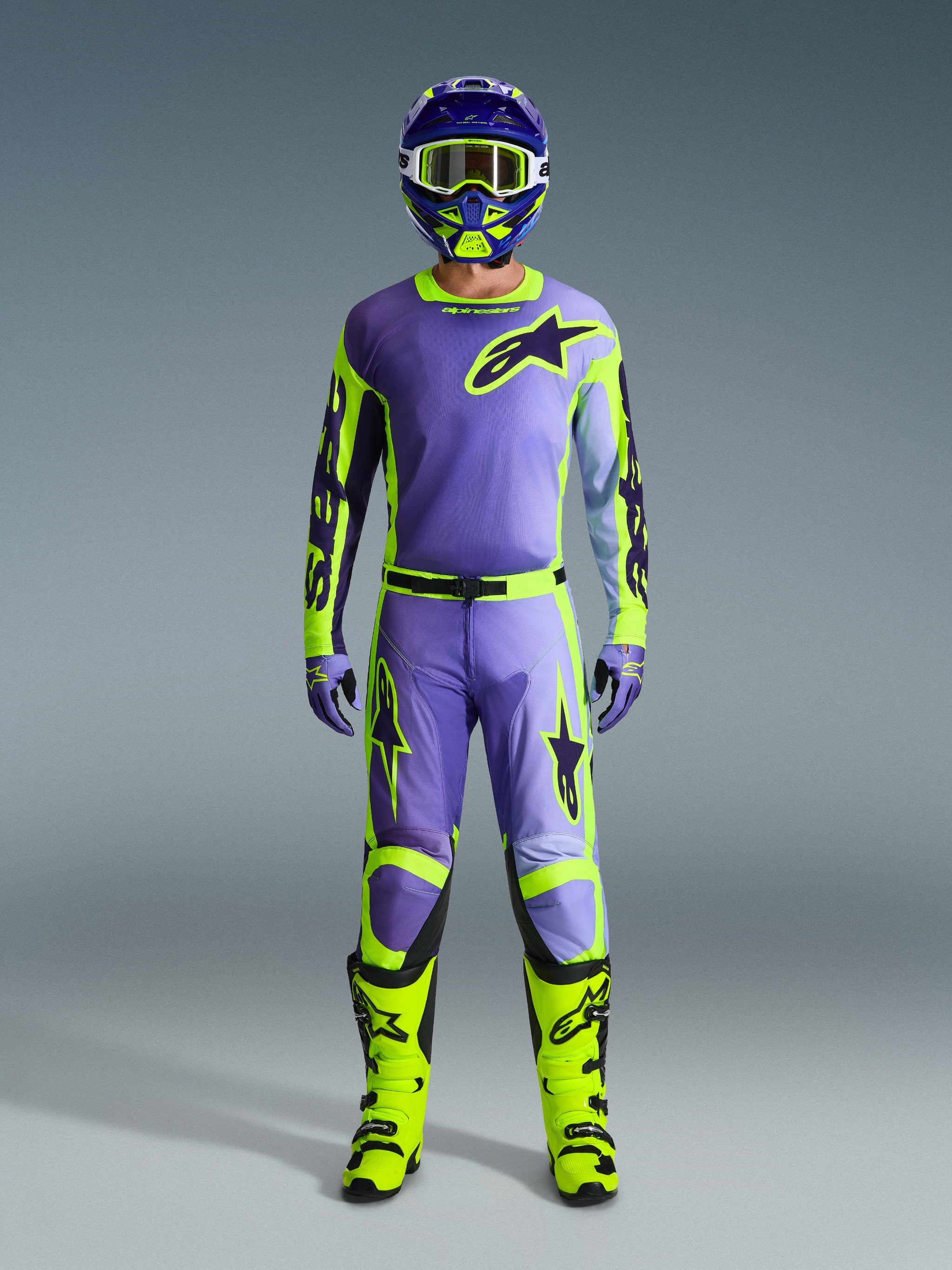 Alpinestars 2026 Racer Portl Pants e set completo da motocross, pilota in viola e giallo fluo con maglia coordinata, casco, occhiali e stivali giallo brillante, abbigliamento per prestazioni fuoristrada