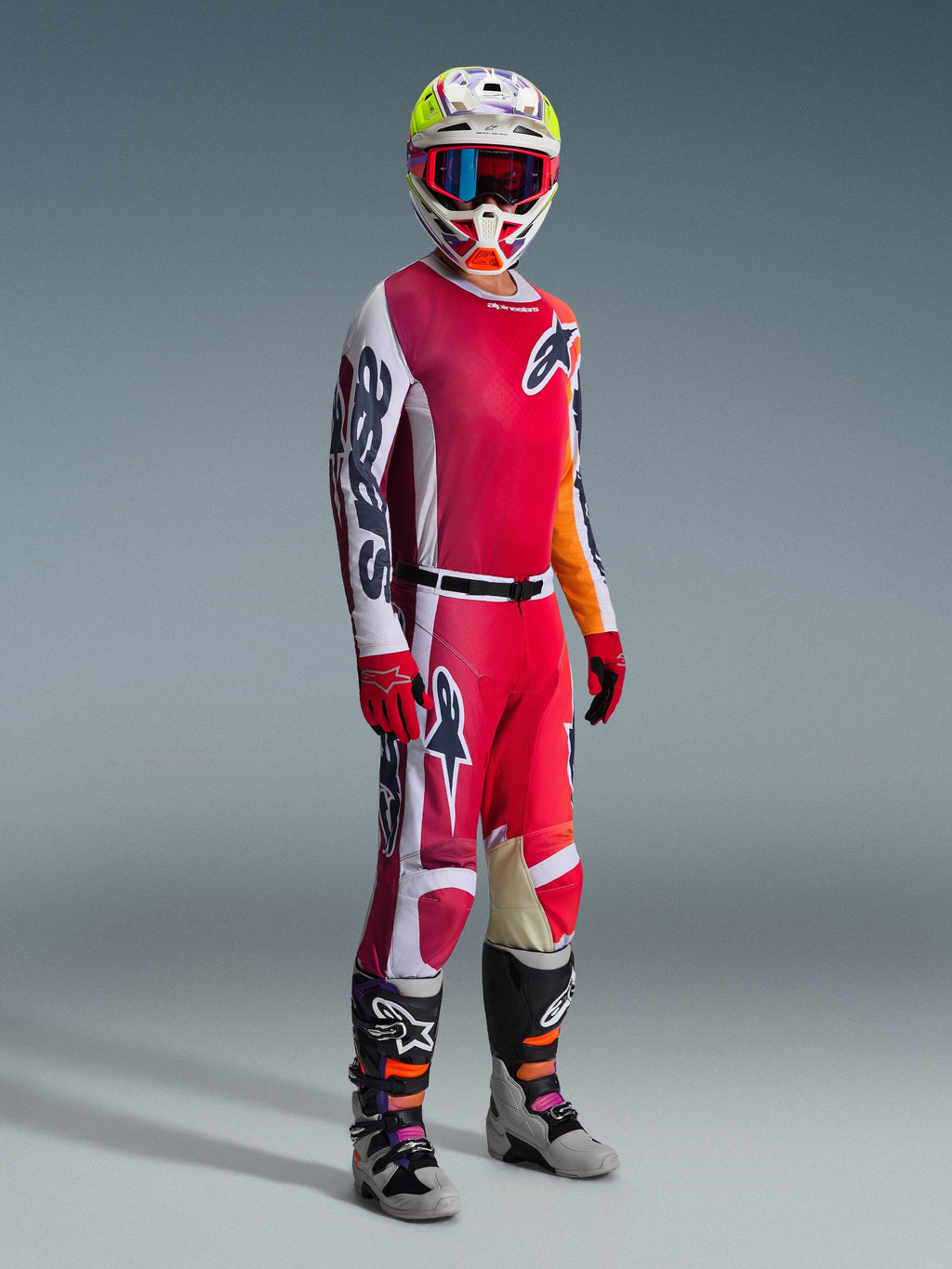Pantaloni Alpinestars Racer Portl 2026, pantaloni da motocross, rosso, grigio chiaro e grigio scuro, indossati come parte di un set completo da gara con maglia coordinata, guanti rossi, casco colorato con occhiali blu e stivali grigi, costruzione resistente per prestazioni motocross off-road.