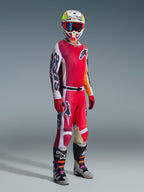 Pantaloni Alpinestars Racer Portl 2026, pantaloni da motocross, rosso, grigio chiaro e grigio scuro, indossati come parte di un set completo da gara con maglia coordinata, guanti rossi, casco colorato con occhiali blu e stivali grigi, costruzione resistente per prestazioni motocross off-road.