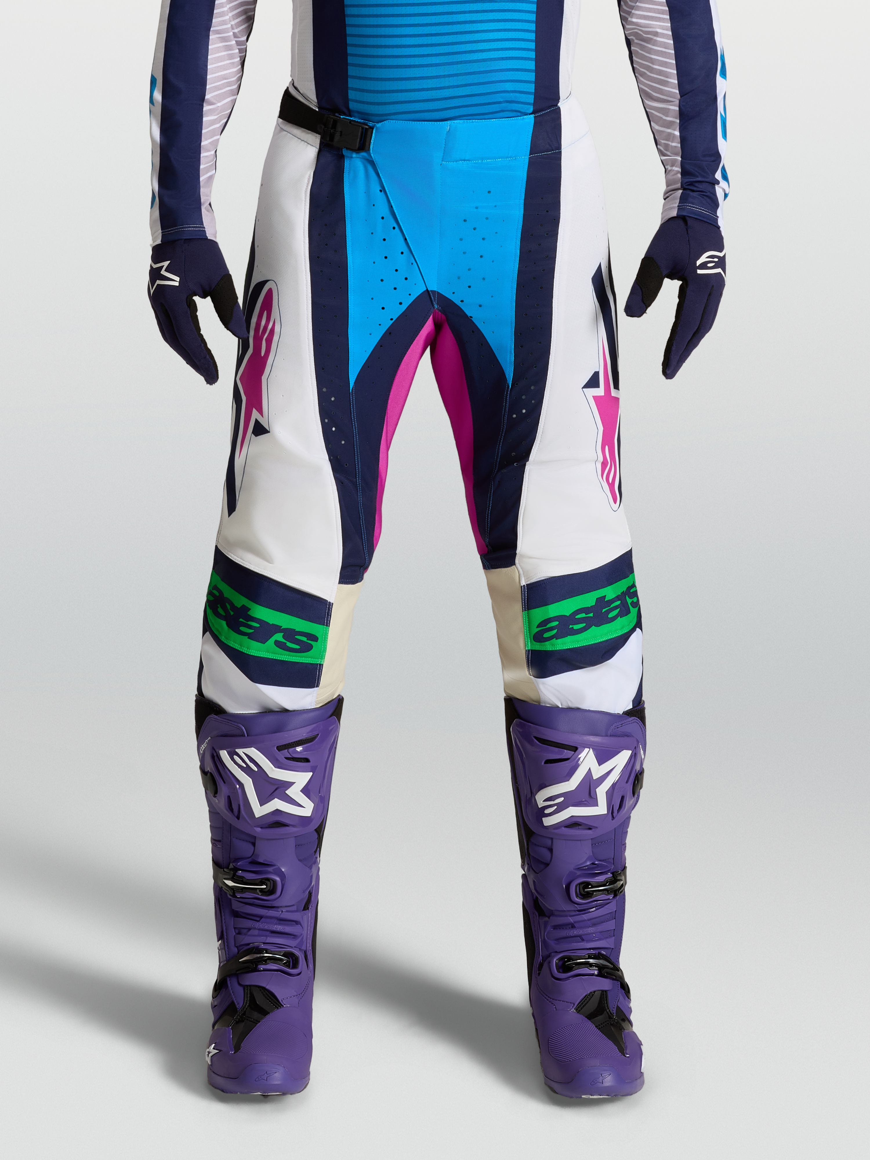 Alpinestars Pantaloni Techstar Maven, pantaloni motocross bianco e blu con dettagli rosa, costruzione del ginocchio Babel 3D, indossati da modella, frontale.