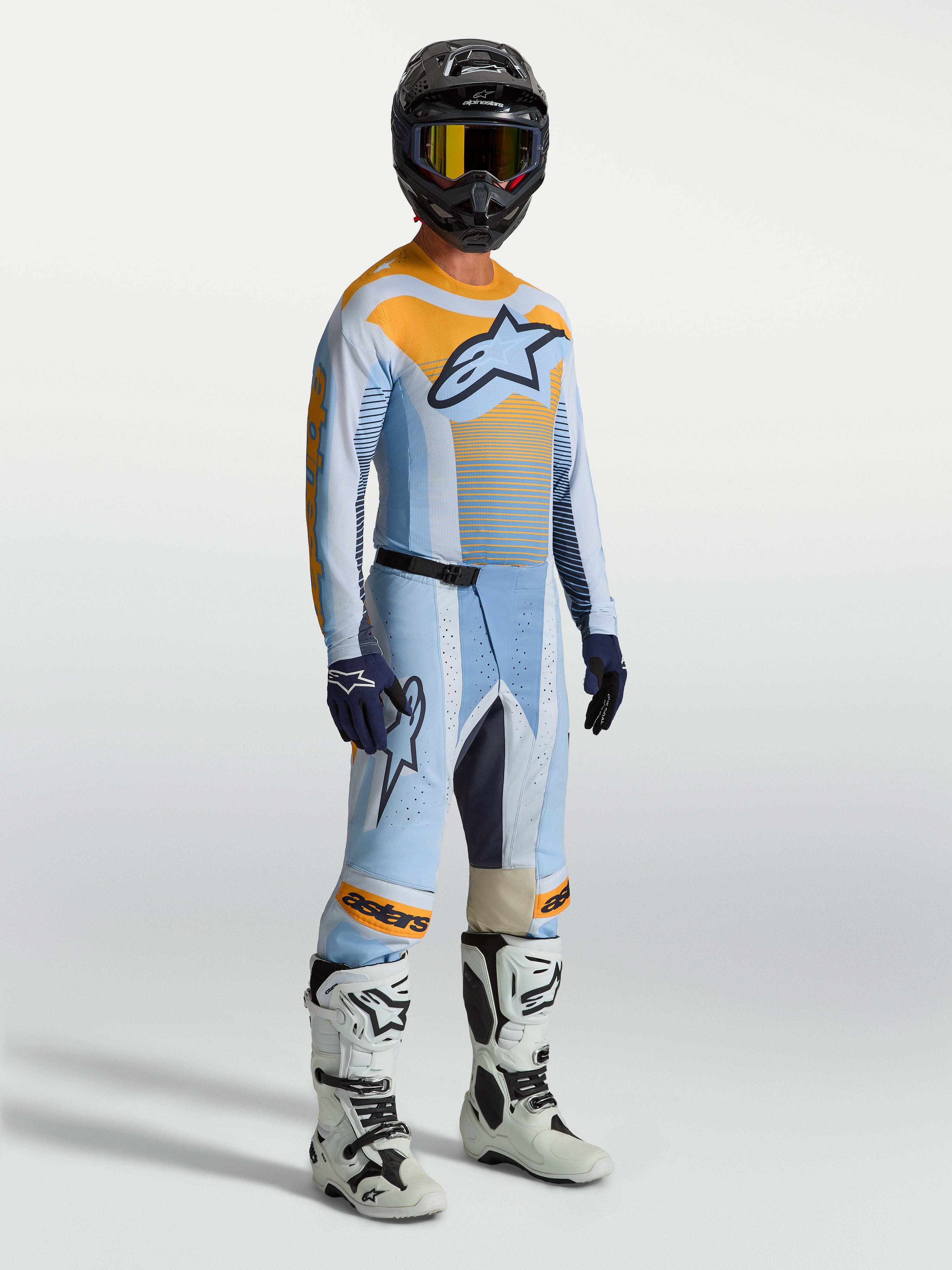 Alpinestars pantaloni Techstar Maven, pantaloni da motocross da uomo, blu e arancione, vestibilità racing, indossati da un pilota.