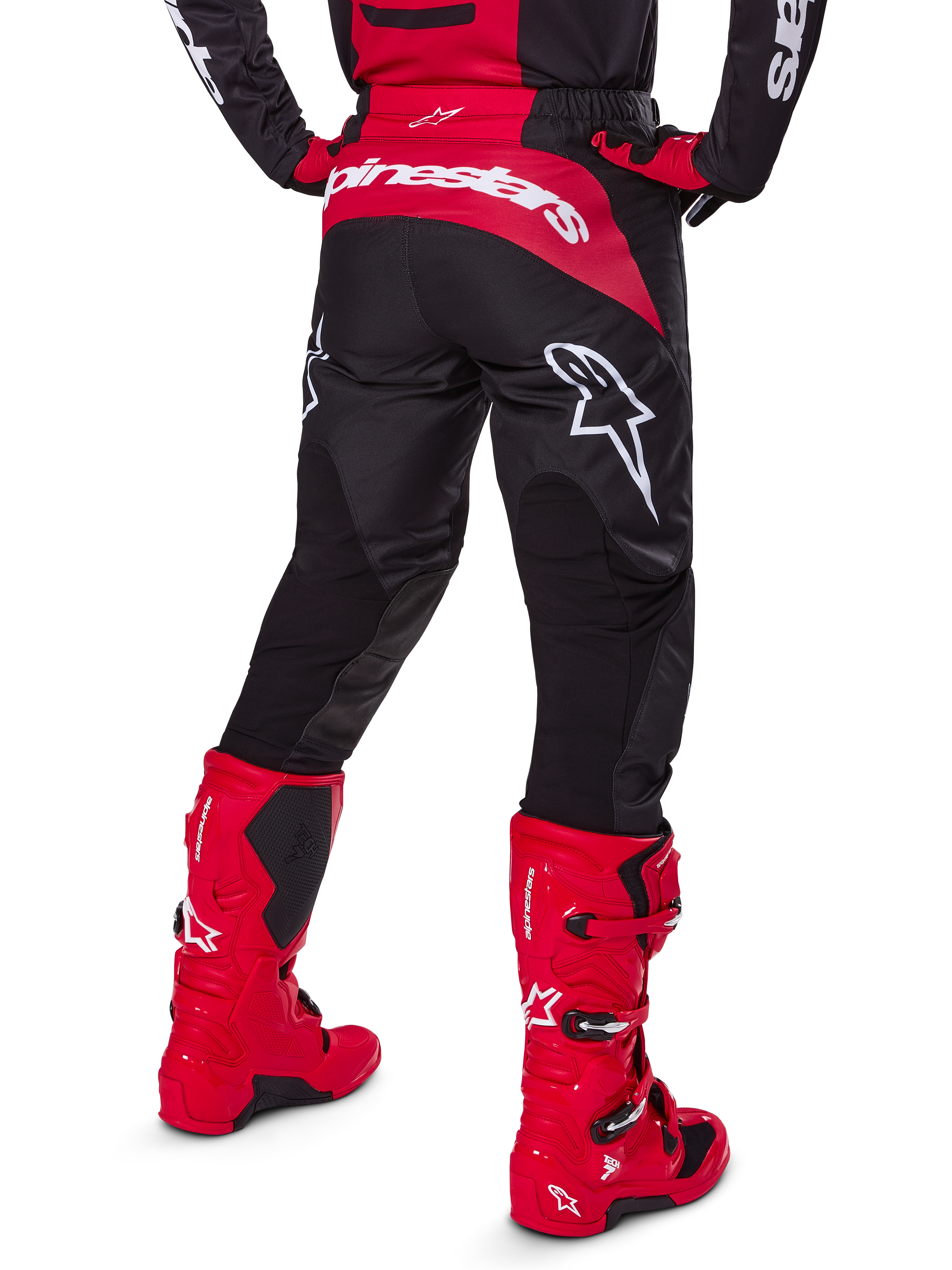 Alpinestars Set Gear Fluid Haul 2025, vista posteriore, pantaloni da motocross neri e rossi con grandi loghi bianchi, maglia coordinata e stivali Tech 7 in rosso vivace, kit da gara fuoristrada coordinato