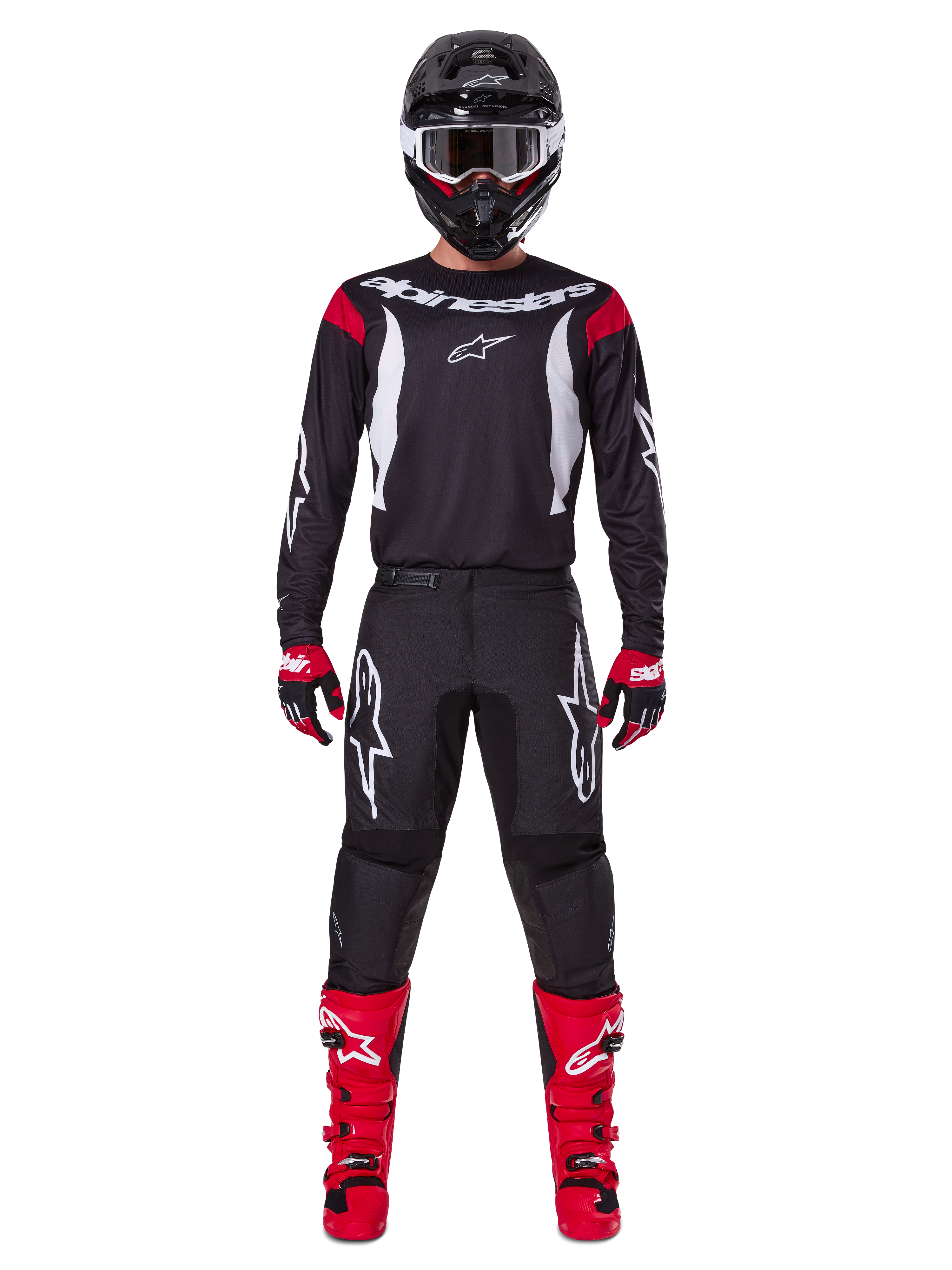 Alpinestars 2025 Fluid Haul Gear Set, pilota di motocross in abbigliamento completo, maglia nera con dettagli rossi sulle spalle e loghi bianchi, pantaloni neri con logo a stella bianco, stivali rosso acceso, guanti rossi e neri, casco nero con occhiali bianchi, look coordinato per prestazioni off-road