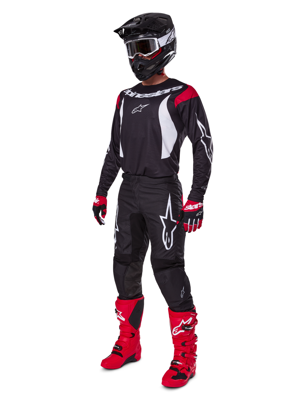 Pilota da motocross con set completo Alpinestars 2025 Fluid Haul, maglia nera con dettagli rossi e bianchi, pantaloni neri con loghi bianchi, stivali rosso acceso, guanti rossi e neri, casco nero con maschera, abbigliamento tecnico coordinato per fuoristrada