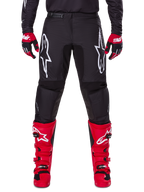 Alpinestars 2025 Fluid Haul Gear Set, pantaloni da motocross neri con loghi Astars bianchi sulle cosce, abbinati a vivaci stivali rossi e guanti rossi e neri, completo da motocross coordinato per corse fuoristrada