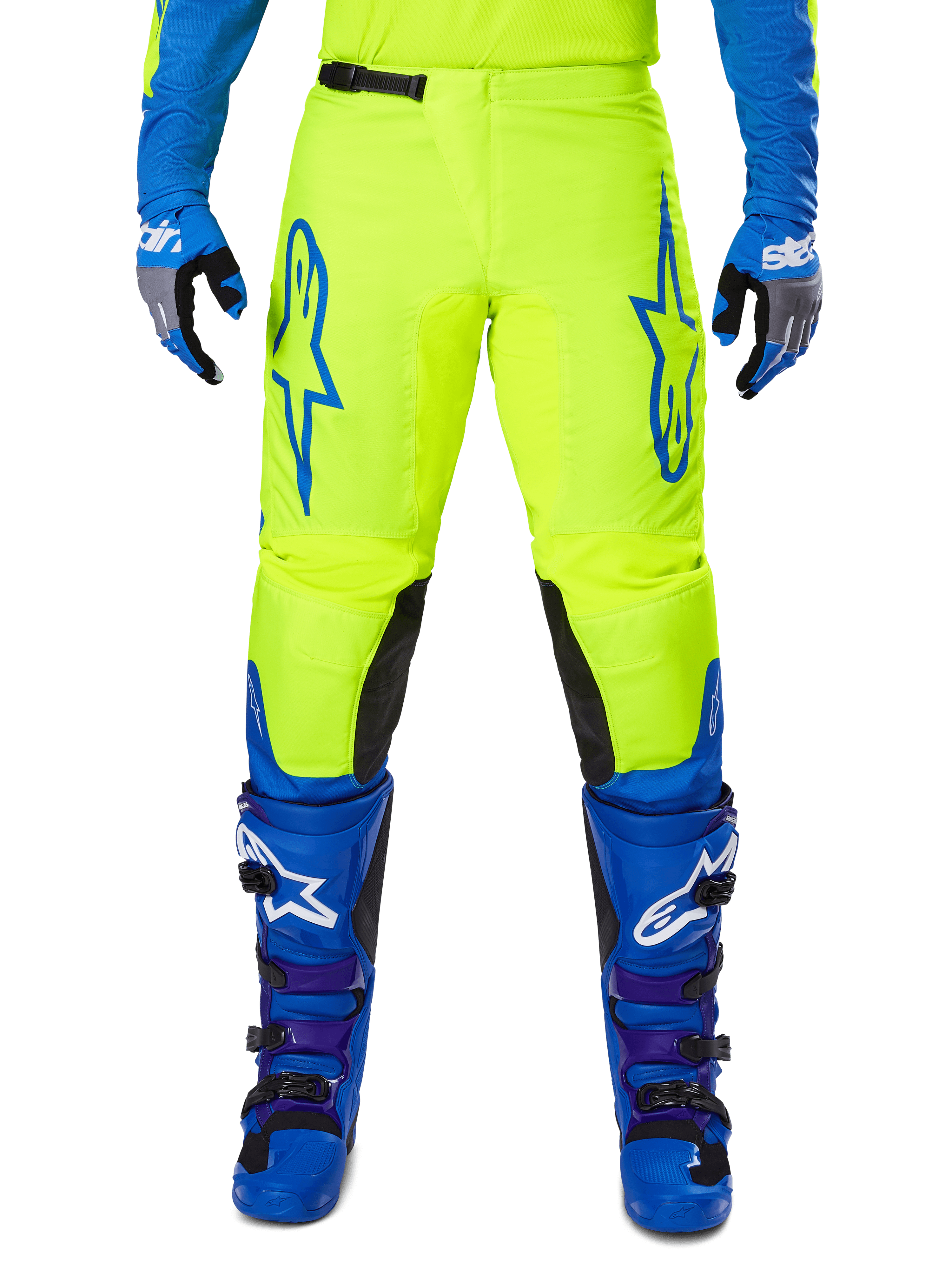 Alpinestars 2025 Fluid Haul Pants, pantaloni da motocross, giallo brillante e blu, indossati con guanti e stivali coordinati, con pannelli interni neri sulle ginocchia, loghi blu sulle cosce e design sportivo ergonomico.