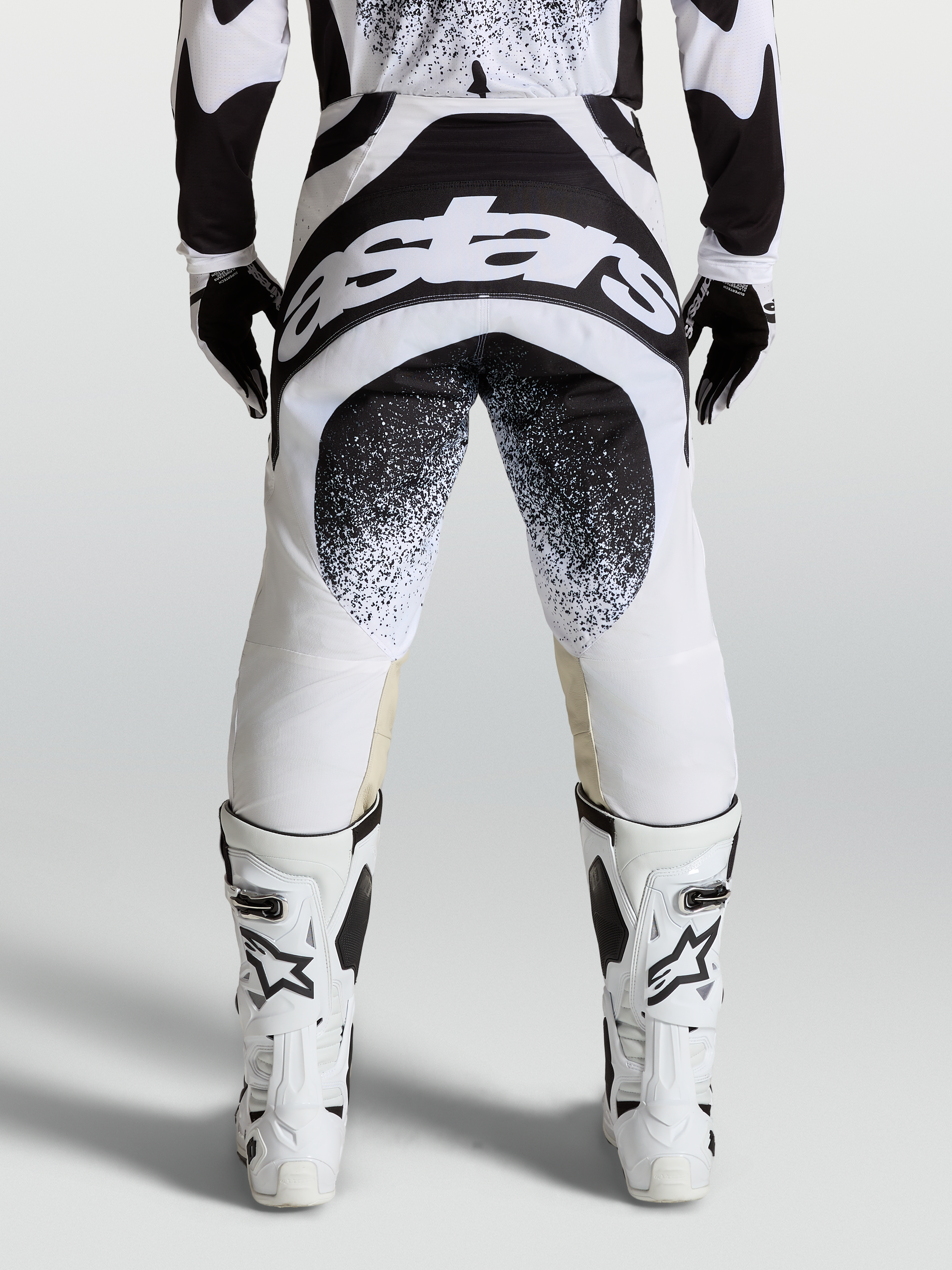 Alpinestars Pantaloni Techstar Swan, pantaloni da motocross neri e bianchi, vista posteriore con grafica logo Astars, costruzione Babel del ginocchio, abbigliamento racing fuoristrada professionale