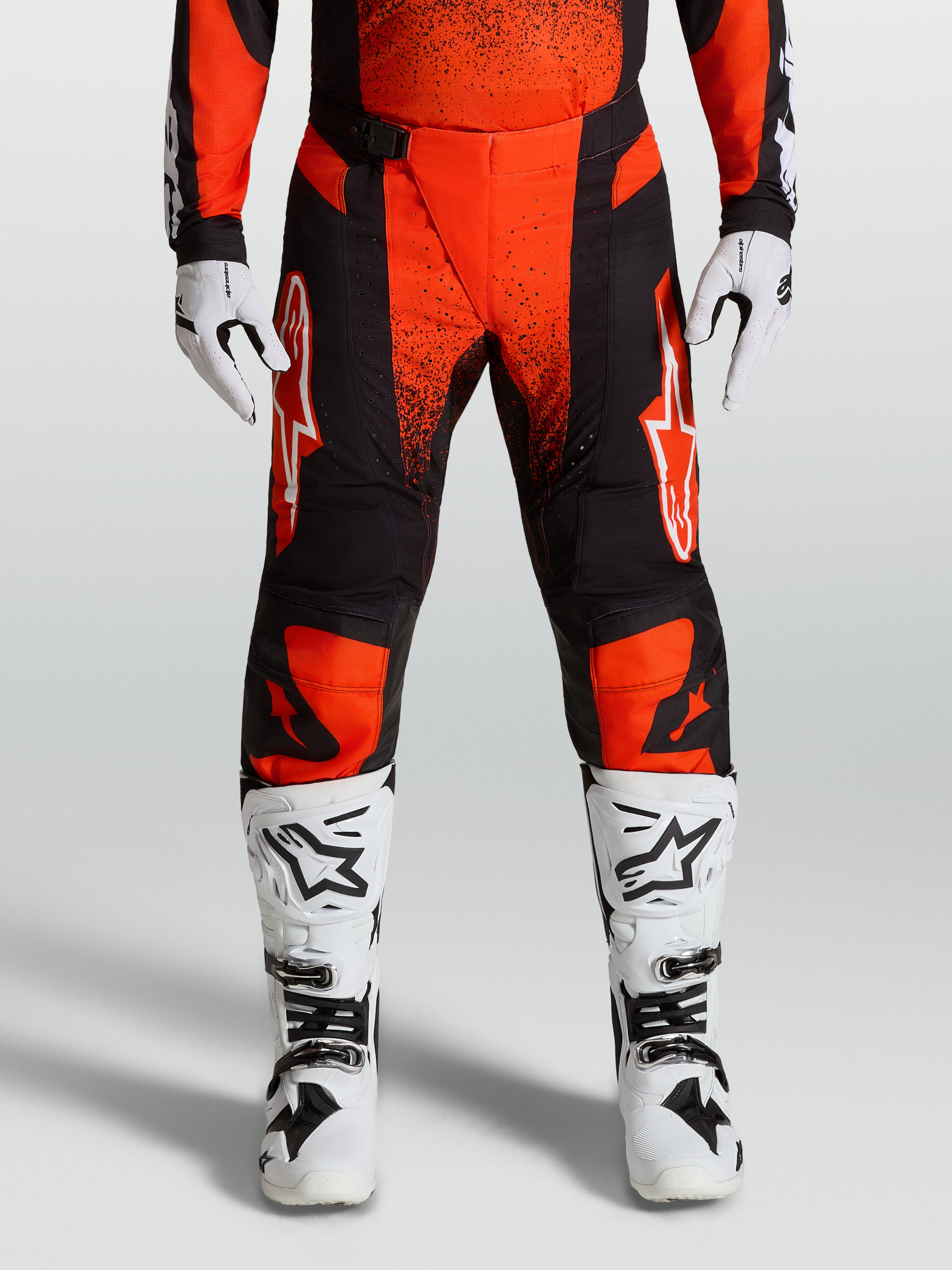 Alpinestars Pantaloni Techstar Swan, pantaloni da motocross Rossi e Neri, indossati con stivali e guanti Bianchi da gara, attrezzatura fuoristrada tecnica