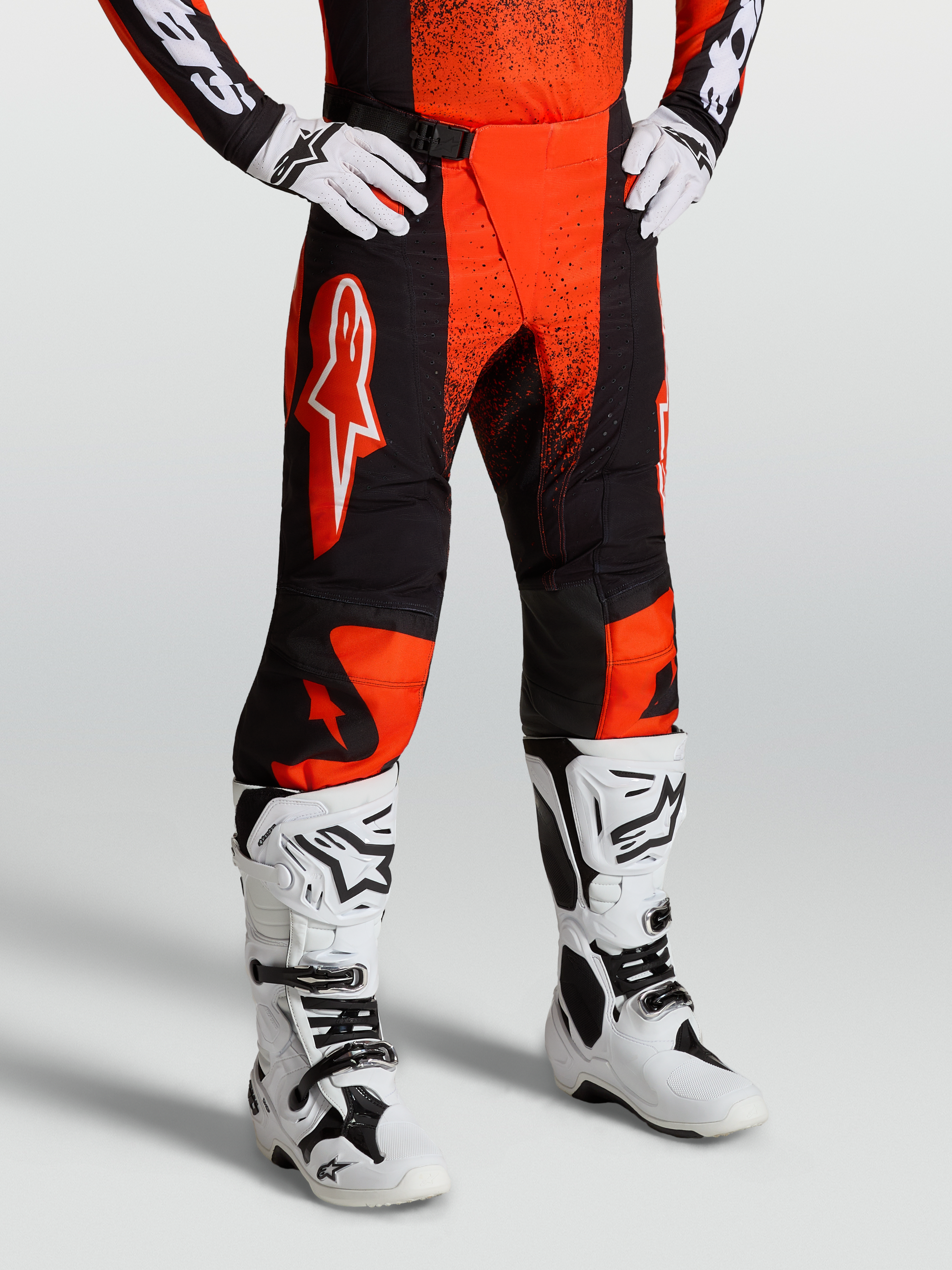 Alpinestars Pantaloni Techstar Swan, pantaloni da motocross da uomo, rosso cardinale e nero, indossati con stivali bianchi, pannelli ripstop elasticizzati per corse fuoristrada ed enduro