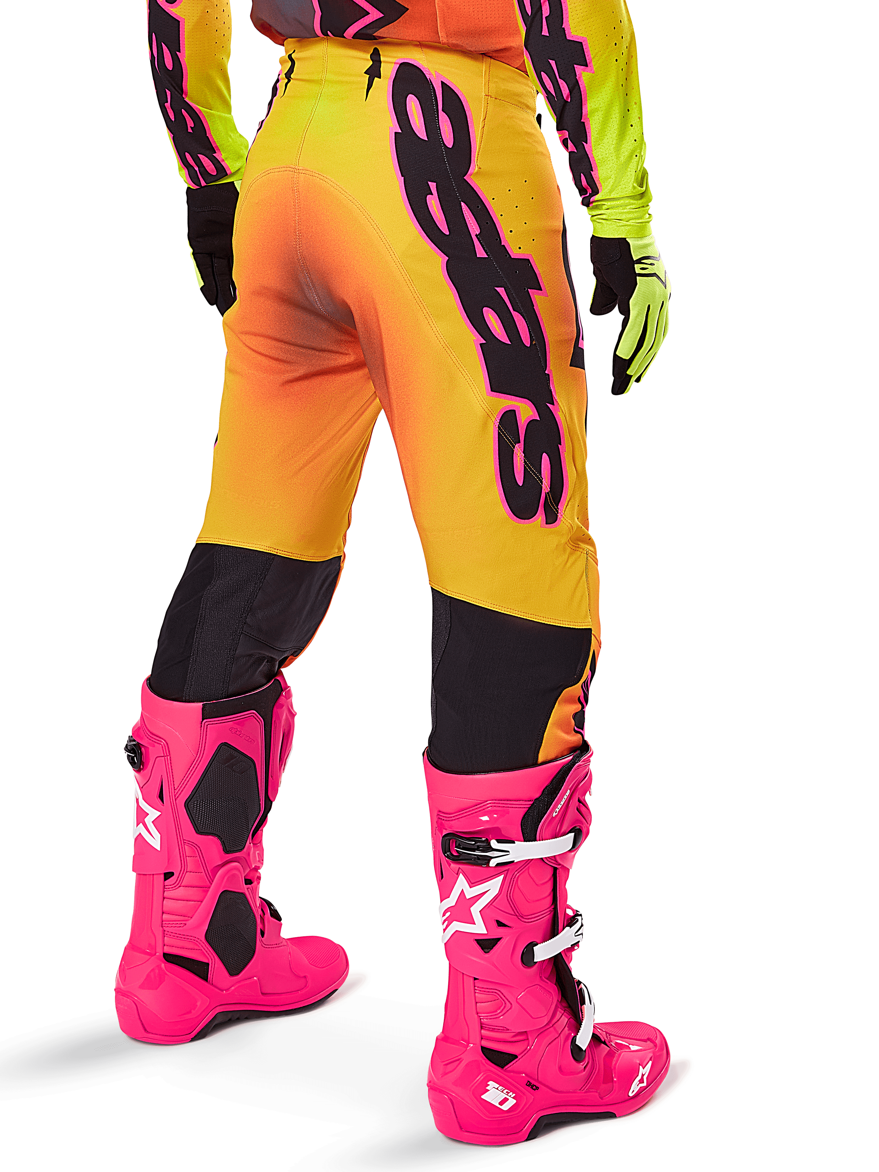 Alpinestars 2025 Supertech Lipan Gear Set, vista posteriore di pantaloni da motocross con sfumatura giallo e arancione e branding nero audace, abbinati a stivali Tech 10 rosa acceso e guanti gialli, attrezzatura professionale per corse fuoristrada