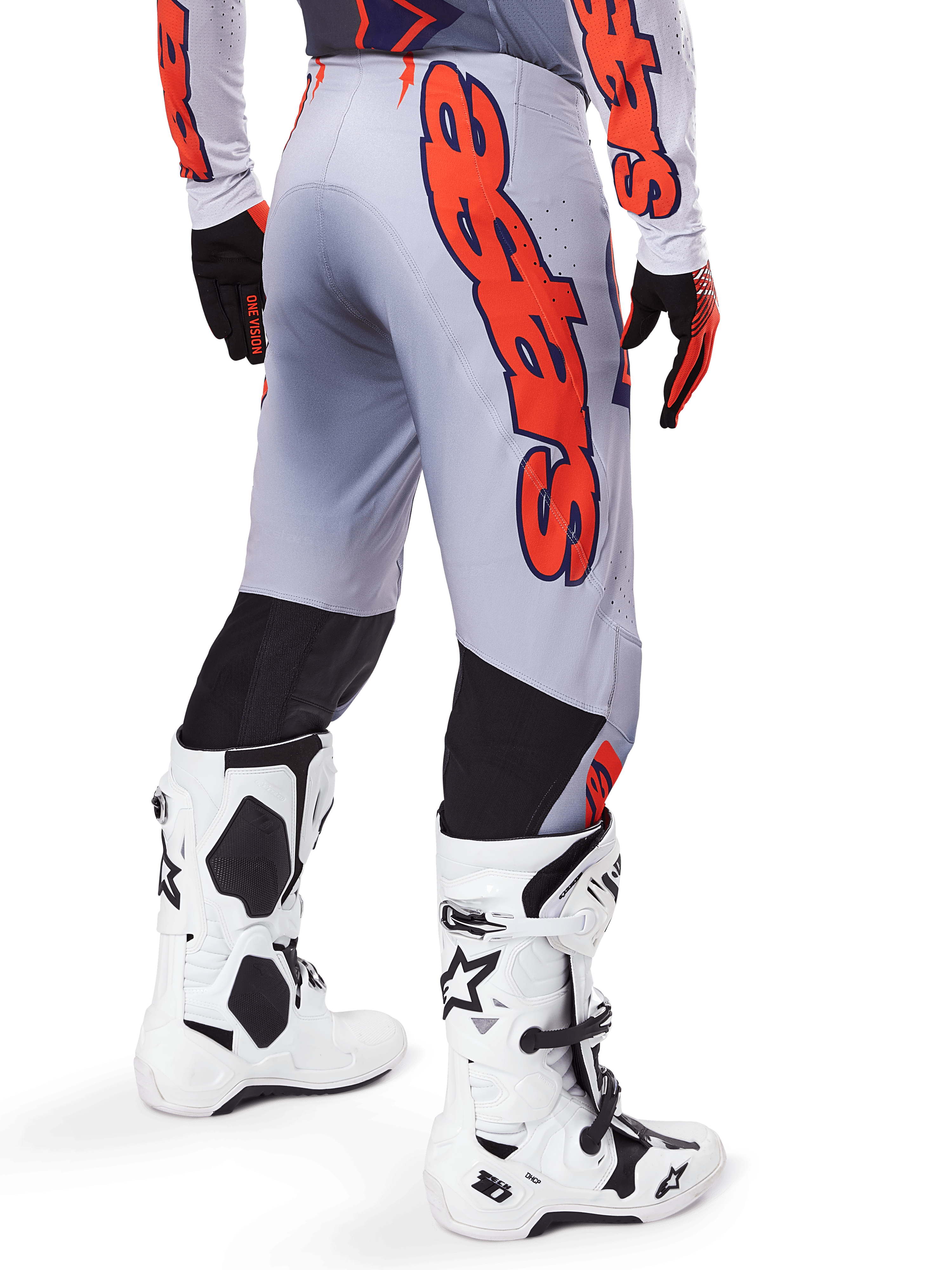 Pantaloni Alpinestars Supertech Lipan 2025, pantaloni da motocross, grigio e arancione fluo, indossati con maglia coordinata e stivali bianchi, vista posteriore con grande grafica arancione del marchio Alpinestars, pannelli elasticizzati neri, abbigliamento professionale per motocross
