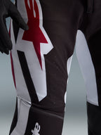 Alpinestars 2026 Supertech AFD Vista Pants, pantaloni da motocross, nero, rosso e bianco, vista ravvicinata della coscia con grande logo Astars rosso e bianco e perforazioni tagliate al laser per la ventilazione.