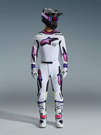 Abbigliamento completo da motocross Alpinestars, maglia e pantaloni Supertech AFD Vista 2026 bianco, viola e nero, guanti coordinati, stivali bianchi e neri, casco nero con maschera viola, vestibilità atletica per prestazioni off-road