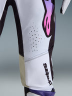Primo piano dei pantaloni Supertech AFD Vista 2026, White Purple Black, con perforazioni tagliate al laser per la ventilazione, pannelli interni al ginocchio in pelle di capra e logo con sfumatura viola-rosa su base bianca e nera, abbigliamento professionale da motocross.