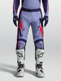 Alpinestars pantaloni Racer Air Hunt, pantaloni da motocross uomo viola e rosa fluo, indossati con stivali bianchi.