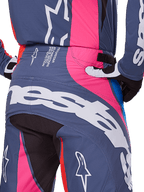 Alpinestars 2025 Techstar Dreem Pants, pantaloni da motocross, grigio multicolore con accenti rosa e bianchi, dettaglio della vista posteriore con grande marchio Alpinestars sulla seduta e testo delle specifiche tecniche sulla vita, indossati come parte di un set da gara coordinato.