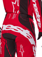 Alpinestars 2025 Techstar Dreem Pants, pantaloni da motocross, rosso acceso e nero, primo piano della zona posteriore della vita e della seduta con branding Alpinestars bianco, pannelli elasticizzati neri e testo tecnico sulla fascia in vita, progettati per prestazioni racing fuoristrada