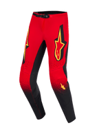 Alpinestars 2026 Supertech Scenz Pants, pantaloni da motocross, rosso, nero e giallo, parte superiore rossa sfumata verso il nero sulla parte inferiore delle gambe con gradiente puntinato, grandi loghi Alpinestars gialli sulle cosce, pannelli interni delle ginocchia neri e chiusura magnetica in vita
