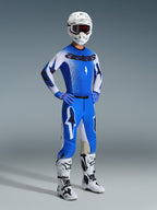 Pilota di motocross con abbigliamento completo da gara, Pantaloni Supertech Scenz 2026 in UCLA Blue e bianco, maglia coordinata blu e bianca con logo Astars, casco bianco con maschera rossa, stivali bianchi e neri, outfit coordinato per competizioni professionistiche fuoristrada.