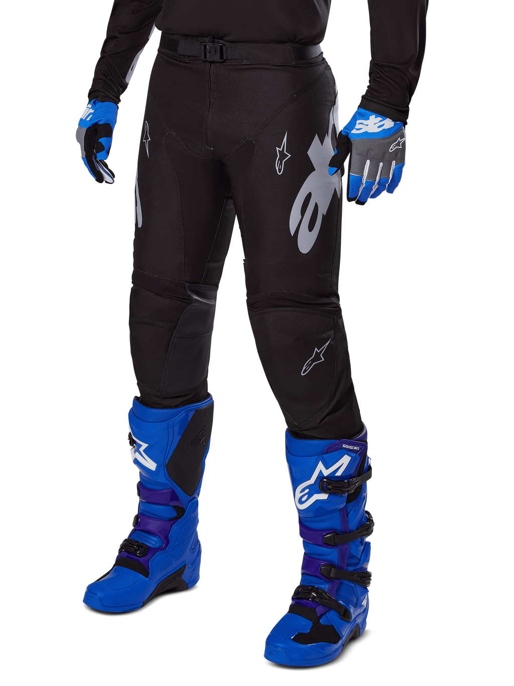 Alpinestars Pantaloni Racer Graphite 2025, pantaloni da motocross neri con grafiche bianche e grigie, indossati con stivali da motocross blu acceso e guanti blu coordinati, tessuto tecnico resistente per il fuoristrada