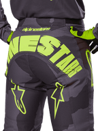 Alpinestars 2025 Racer Hollow Pants, pantaloni da motocross, Dark Camo e Giallo Fluo, grande logo Alpinestars giallo sul retro, motivo mimetico tattico con accenti giallo acceso, costruzione resistente per corse fuoristrada