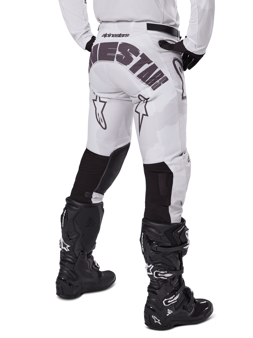 Alpinestars Racer Hollow 2025, pantaloni da motocross, Light Camo Brown, vista posteriore del pilota con grande marchio sulla seduta e pannelli elasticizzati neri sulla parte inferiore delle gambe, abbinati a stivali Tech 7 neri
