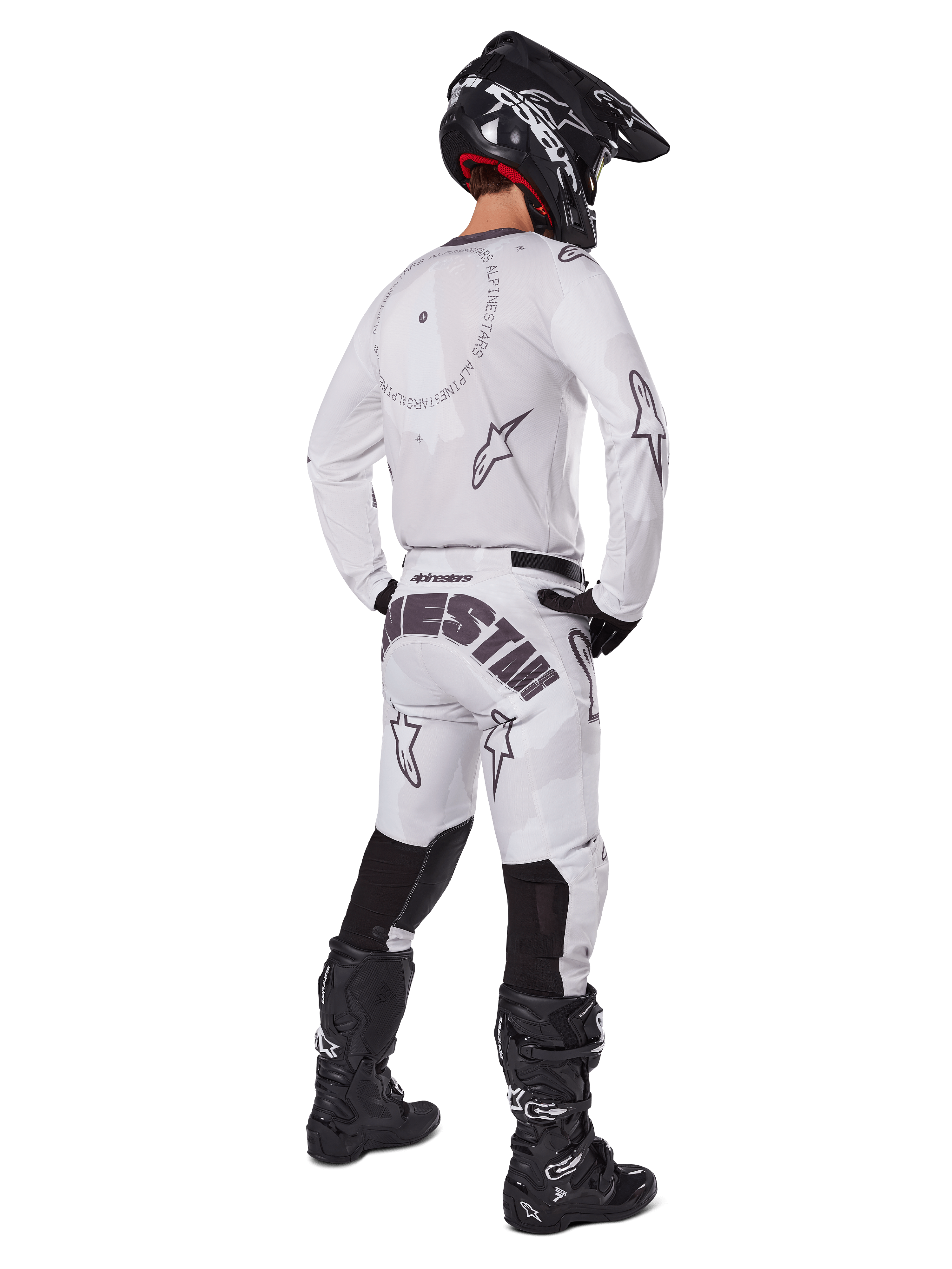 Alpinestars 2025 Racer Hollow Pants, pantaloni da motocross, Light Camo Brown e bianco, vista posteriore con vistoso marchio nero sulla seduta e loghi a stella, indossati con maglia coordinata, stivali neri e casco nero per un look racing off-road completo