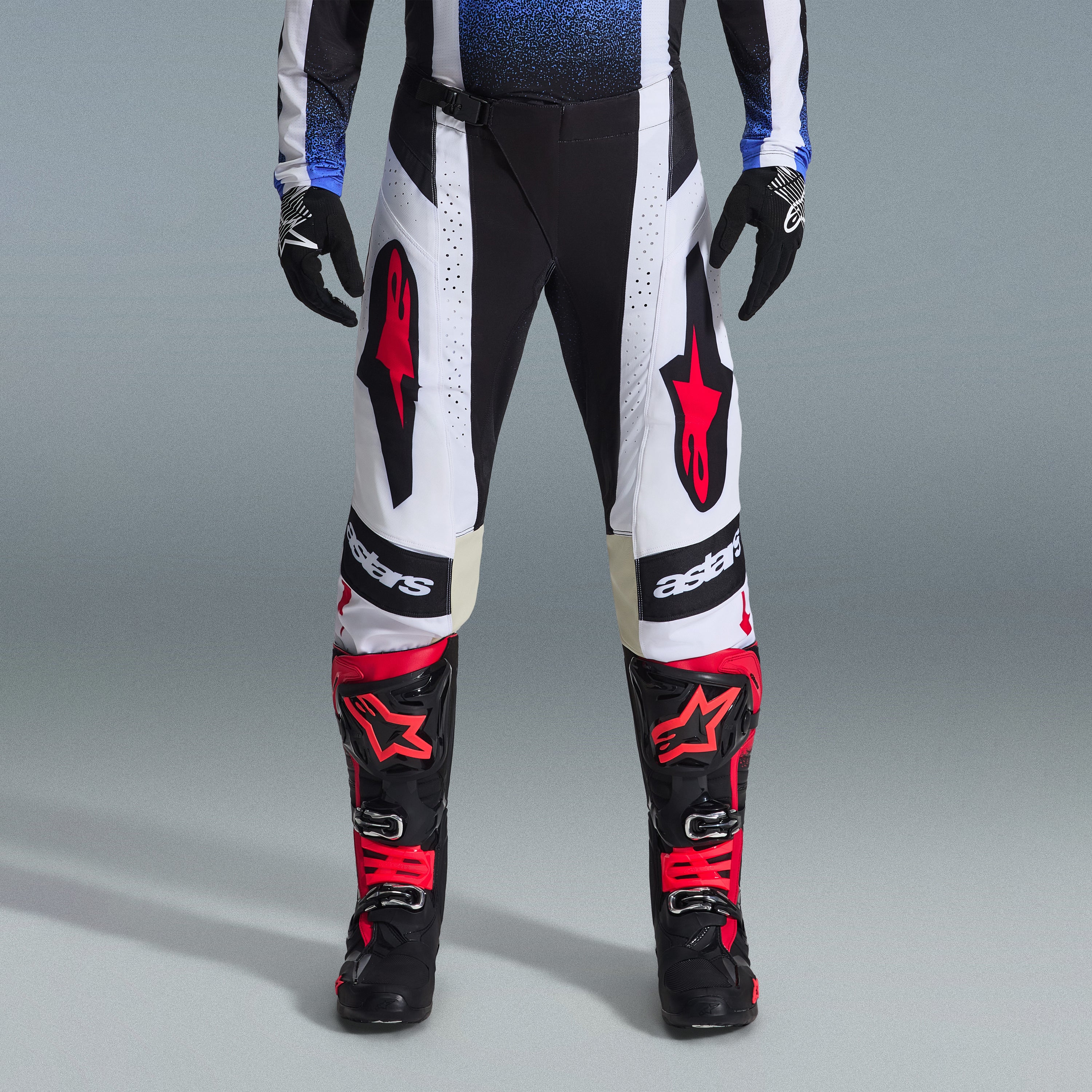 Set Completo Alpinestars Techstar Knif 2026, abbigliamento da motocross, pantaloni bianchi e neri con grandi loghi a stella rossi, indossato con stivali da gara neri e rossi e guanti neri, vestibilità atletica professionale per prestazioni off-road