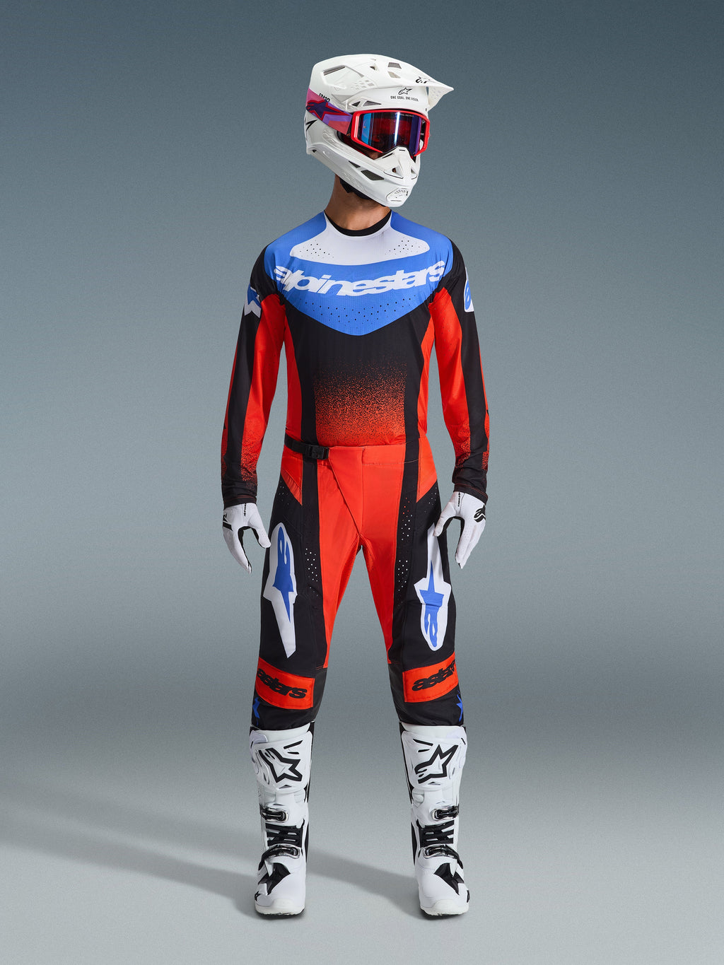 Set Alpinestars 2026 Techstar Knif, abbigliamento da motocross, rosso e nero con accenti blu, completo MX composto da maglia, pantaloni, casco bianco con grafiche rosa e blu, guanti bianchi e stivali bianchi, equipaggiamento professionale per corse fuoristrada