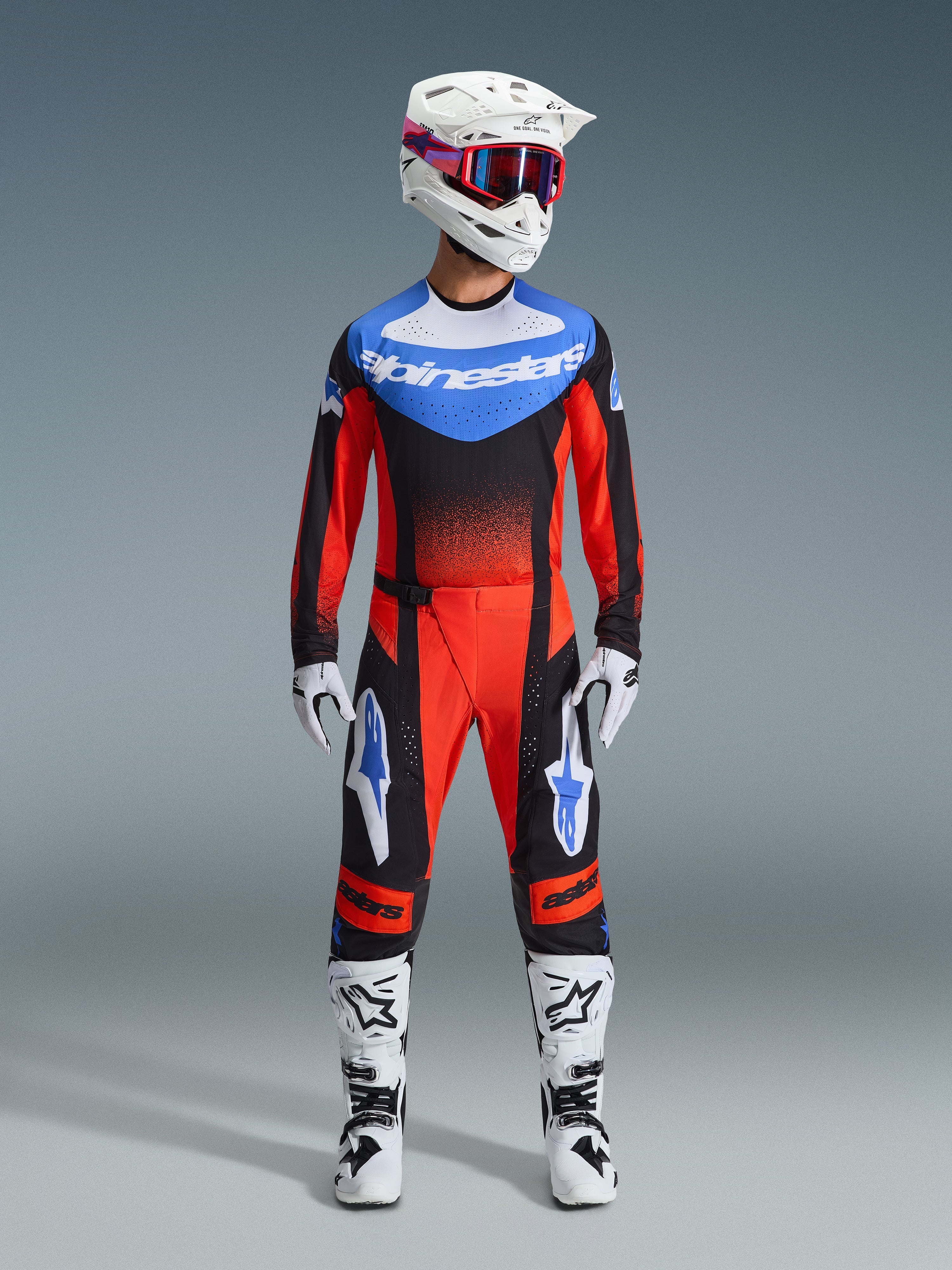Set Alpinestars 2026 Techstar Knif, abbigliamento da motocross, rosso e nero con accenti blu, completo MX composto da maglia, pantaloni, casco bianco con grafiche rosa e blu, guanti bianchi e stivali bianchi, equipaggiamento professionale per corse fuoristrada