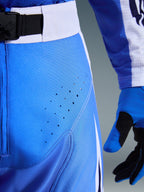 Alpinestars 2026 Techstar Knif Pants, pantaloni da motocross, blu Ucla e nero, vista ravvicinata della coscia con perforazioni tagliate al laser e fibbia magnetica SX2 in vita, costruzione tecnica per corse off-road