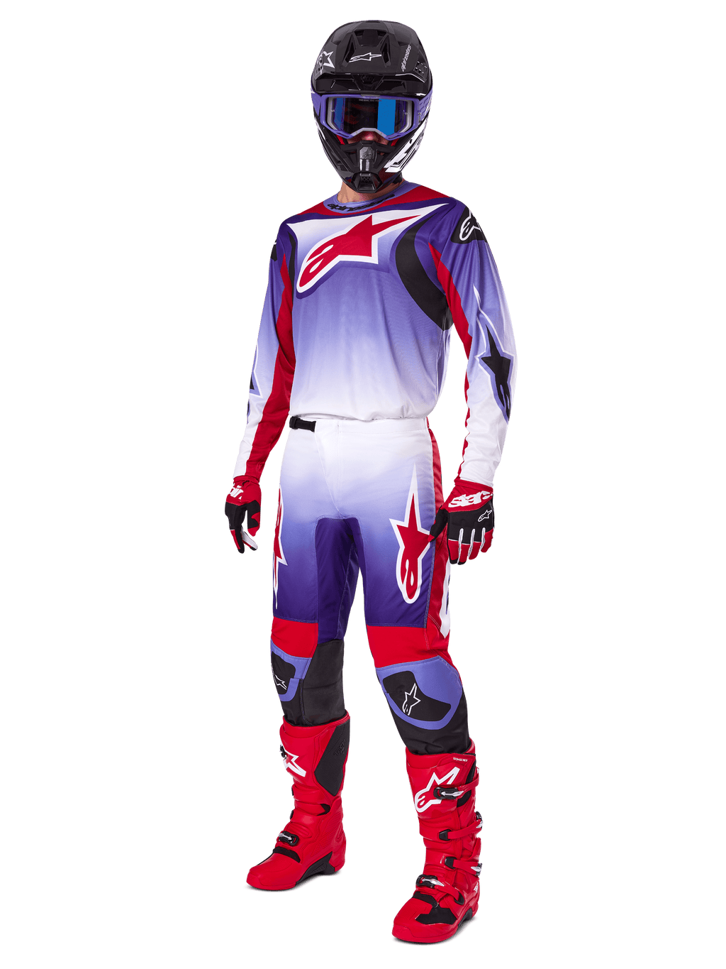 Pilota di motocross con abbigliamento da gara completo, pantaloni Fluid Wurx 2025 e maglia coordinata in viola, rosso acceso e bianco, grande logo Alpinestars rosso, stivali e guanti rossi, casco nero con occhiali blu, outfit coordinato per gare off-road