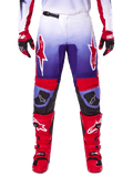 Alpinestars 2025 Fluid Wurx Pants, pantaloni da motocross, viola e rosso acceso, indossati con stivali e guanti rossi coordinati, con loghi bianchi sulle cosce e rinforzi neri sulle ginocchia, abbigliamento tecnico per il fuoristrada