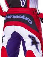 Alpinestars 2025 Fluid Wurx Pants, pantaloni da motocross, viola e rosso brillante, vista posteriore ravvicinata con evidente logo Alpinestars sul pannello della seduta nero, design a blocchi di colore rosso, bianco e viola, abbigliamento professionale per fuoristrada