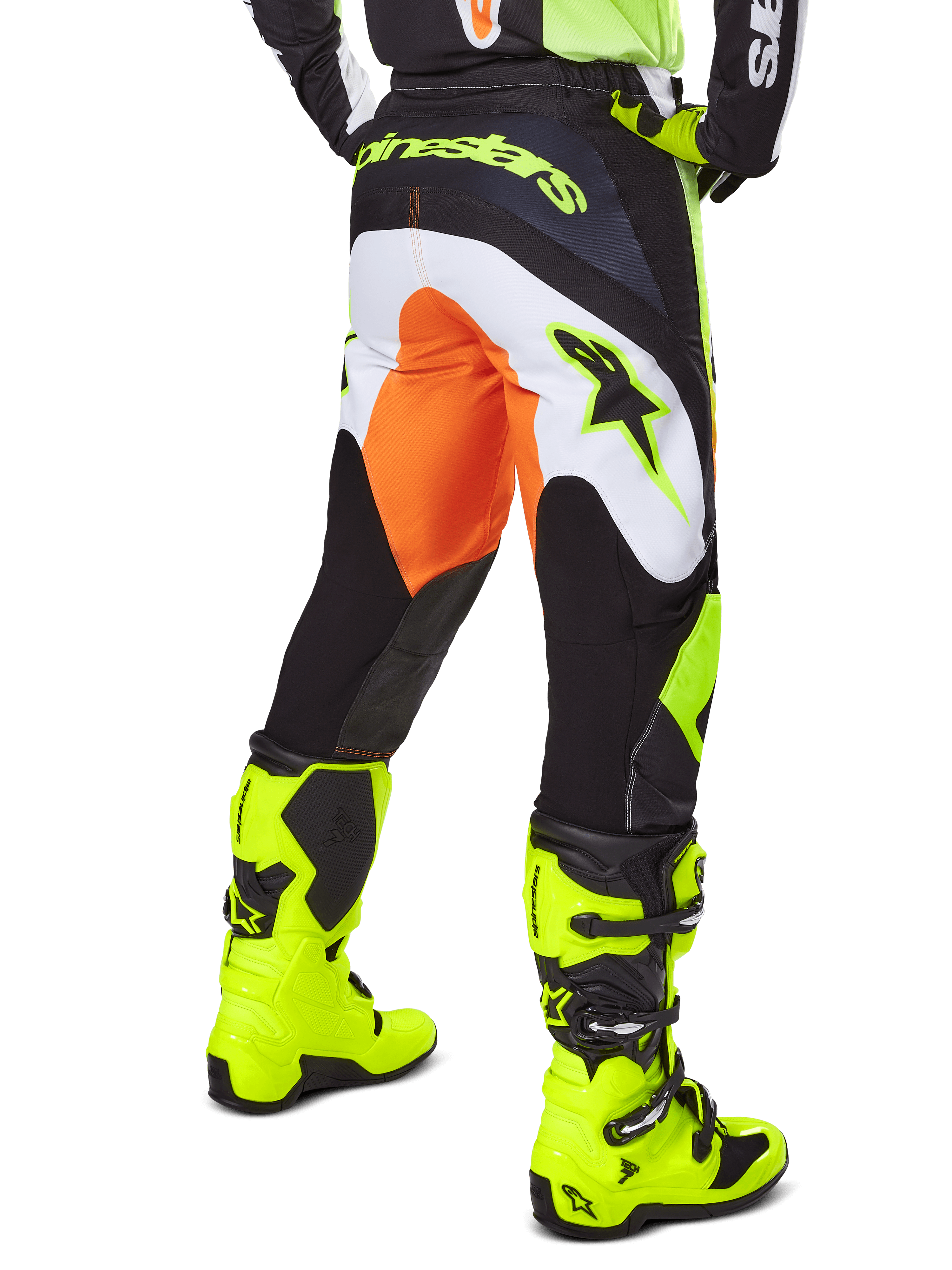 Alpinestars Pantaloni Fluid Wurx 2025, pantaloni da motocross, giallo e nero con dettagli arancioni e bianchi, vista posteriore indossati con stivali giallo brillante coordinati, design resistente per fuoristrada