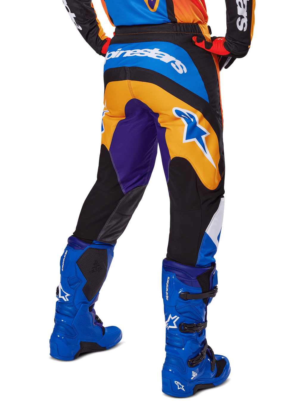Alpinestars pantaloni Fluid Wurx 2025, pantaloni da motocross, multicolore con arancione, viola e blu, vista posteriore che mostra il logo Alpinestars bianco sul retro, abbinati a stivali da motocross blu, vestibilità atletica per gare off-road
